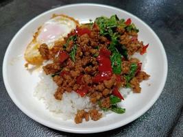Stir fried minced pork and chili mix with basil on top steamed rice, hot and spicy photo