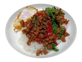 Stir fried minced pork and chili mix with basil on top steamed rice, hot and spicy, isolated on white background with clipping path photo