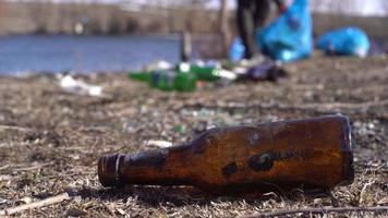 milieuvervuiling. glazen fles en afvalinzameling. milieuactivist die glas- en plasticafval in de natuur inzamelt. het probeert milieuvervuiling te voorkomen door afval in te zamelen. video