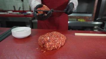 maître turc de kebab d'adana. le chef prépare adana kebab. ficelle de viande sur brochette. brochette de viande. video