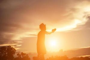 silueta de niño, momentos de alegría del niño. en la puesta de sol de la naturaleza foto