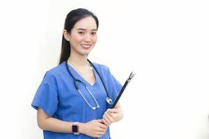 Asian beautiful  woman doctor standing smiling in a blue lab shirt, holding patient documents in hand. Health care concept photo