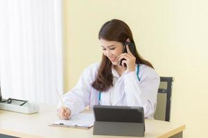 Asian female doctors provide telephone counseling in  health care,new normal and coronavirus protection concept. photo