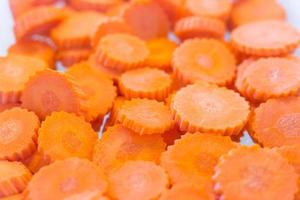 Orange carrots turned into many pieces on a white background. Carrots are a vegetable which rich in useful vitamins and mineral. It was served in Shabu restaurant. photo