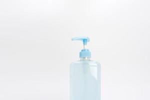 Isolated blue alcohol gel bottle and pump on white background. photo