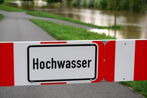 road blocked due to flooding, sign reads high water in German photo