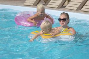 happy family having good time in blue swimming pool photo