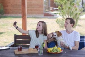 Young couple with beagle dog, happy family have good time in backyard photo