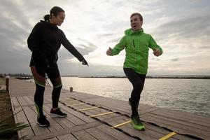 group of young people training outdoors, runners exercises, sea or river background photo