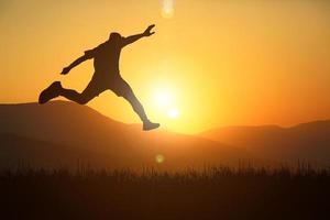 The silhouette of a man is jumping forward. The concept of clawing through hurdles photo