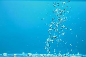 Abstract background image of bubbles in water. Clean water with water droplets and waves. Fresh water a glass with bubbles blue background.