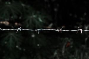 primer plano de una cerca de alambre de púas en un área restringida. foto