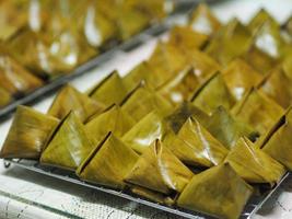 Stuffed Dough Pyramid Dessert Stuffed Dough Pyramid, year cake, Chinese New Year cake, dessert Made with glutinous rice flour and sugar put banana leave small basket and steamed cooked photo