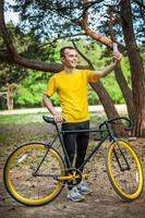 un joven tomándose un selfie con su bicicleta. foto