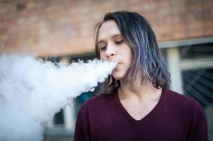 Portrait of a young man in the smoke of cigarettes photo