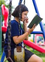 niña leyendo cadenas de columpios. foto