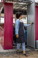A charming woman with her back facing a pink zinc door. photo