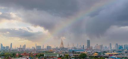 paisaje urbano de edificio moderno con carretera y comunidad en bangkok. edificio rascacielos. horizonte urbano. paisaje urbano con un arco iris en el cielo tormentoso y la luz del sol. nubes de tormenta sobre la ciudad. foto