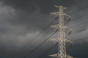 torre de alta tensión con cable eléctrico y cielo oscuro foto
