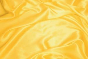 Golden smooth satin or silk texture background. Elegant cloth material textiles. White fabric abstract texture. Luxury satin velvet. Silky and wavy folds of silk texture. Rippled satin cloth photo