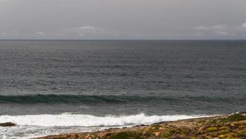 The waves fighting about deserted rocky coast of Atlantic ocean, Portugal photo