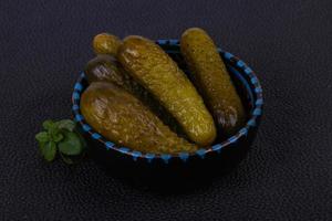 Pickled cucumbers heap in the bowl photo