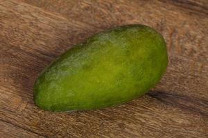 Green tasty mango over wooden background photo