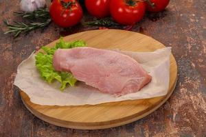 Raw Turkey steak served rosemary photo