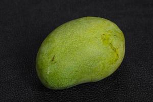 Green tasty mango over wooden background photo