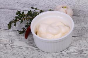 Mayonnaise sauce in the white bowl served thyme and garlic photo