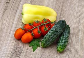 Cucumbers and tomatoes on the branch with yellow pepper photo