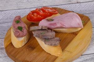 Bruschetta with tomato, ham and tongue photo