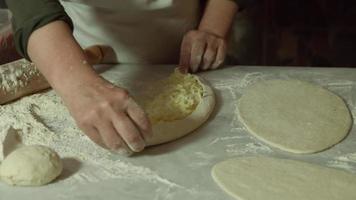 Pita making. Turkish pita. Preparation of pita with cheddar, woman placing cheddar on pita dough. video