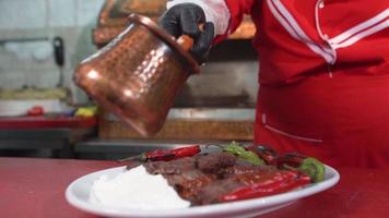Turkey Iskender kebab.  Pouring sauce on meat. video