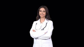 A female doctor smiling and looking at the camera. Female doctor looking at camera and smiling crosses arms. Transparent background. video