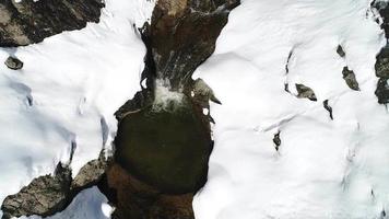 strömma bland snön. underbar utsikt över bäcken som rinner genom snön. video