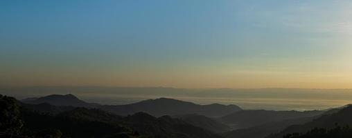 Silhouette of mountains during sunrise with sky and clouds. Beautiful natural landscape in the summertime photo