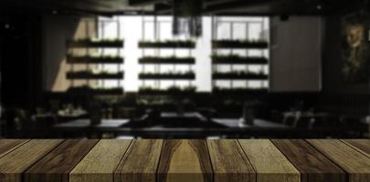 Empty wooden table top in front of abstract blur restaurant background. photo