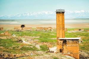 estructura de torre con fondo de montañas. ani ruinas sitio arqueológico anatolia oriental, turquía foto