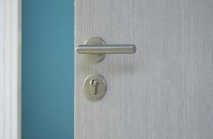 puerta abierta con pomo de puerta de metal en la habitación azul foto