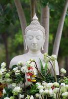 adoración del budismo con ofrenda de flores y guirnaldas a la estatua de buda en el día de magha puja, asalha puja y visakha puja en tailandia foto