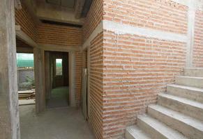 House under construction with red brick wall and stair photo