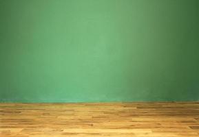 pared verde y suelo de madera maciza en una habitación vacía foto