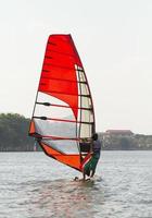 Man winsurfing on calm lake photo