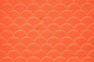 Orange fish scale seamless pattern on decorated cement wall photo