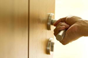 Hand opening wooden door photo