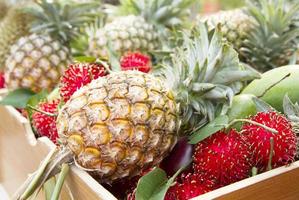 Pineapples and other tropical fruit at asian market photo