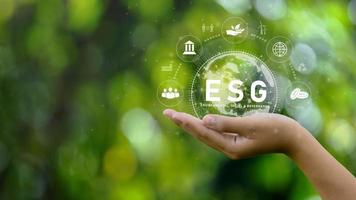 ESG icon concept. Environment in renewable hands. Nature, earth, society and governance SG in sustainable business on networked connections on green background. environmental icon photo