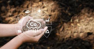 The concept of CO2 emissions in the hands of planting soil for the environment Carbon dioxide emissions, global warming, sustainable development and environmental business from renewable energy. photo