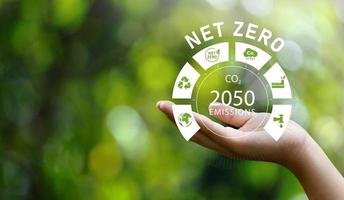 concepto de icono de emisiones netas cero 2050 en la mano para la ilustración del concepto de animación de política ambiental tecnología de energía renovable verde para un entorno futuro limpio. foto